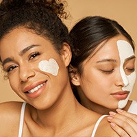 Two women using skincare products